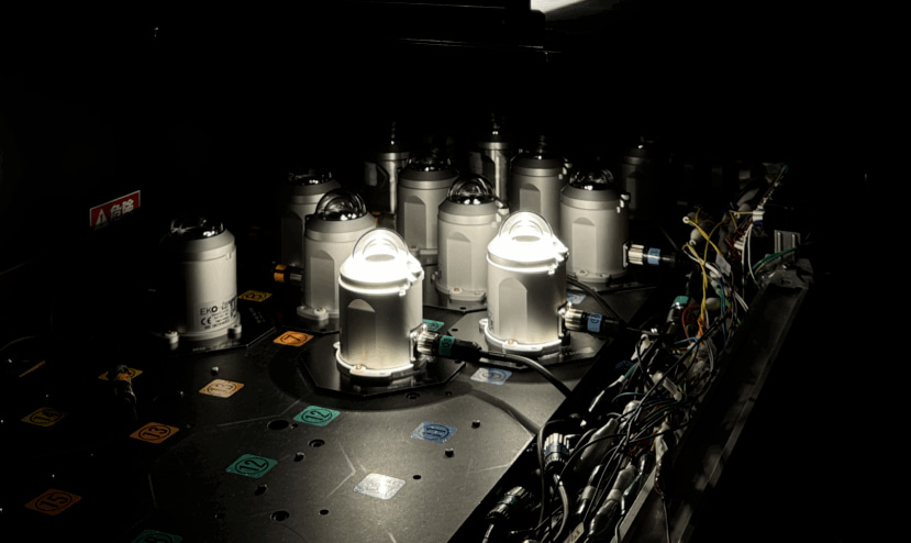 Array of pyranometers on a test bench with controlled lighting and connected wiring.